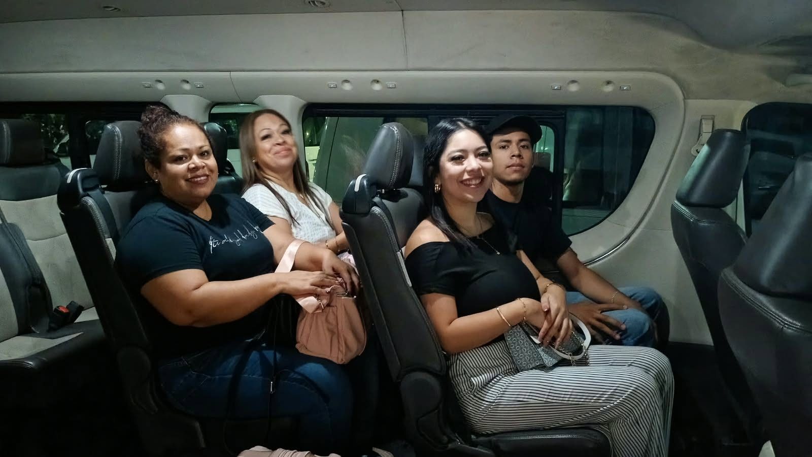 Grupo de pasajeros sonriendo dentro de una van privada de Comfort & Safety Transport