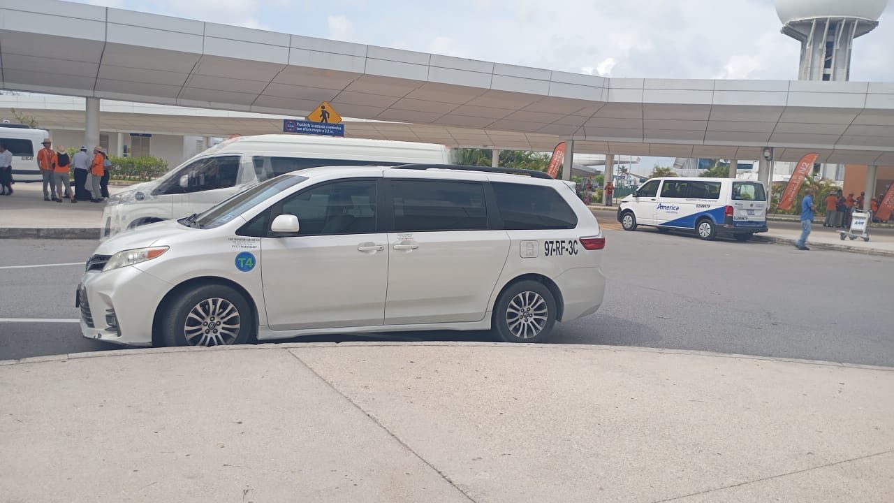 Toyota Sienna blanca de Comfort & Safety Transport frente al aeropuerto de Cancún